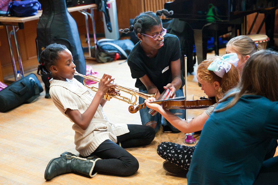 A young girl plays trumpet while participating in an RCM Sparks event